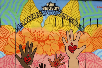 Colorful mural featuring flowers and children's hands in Flint